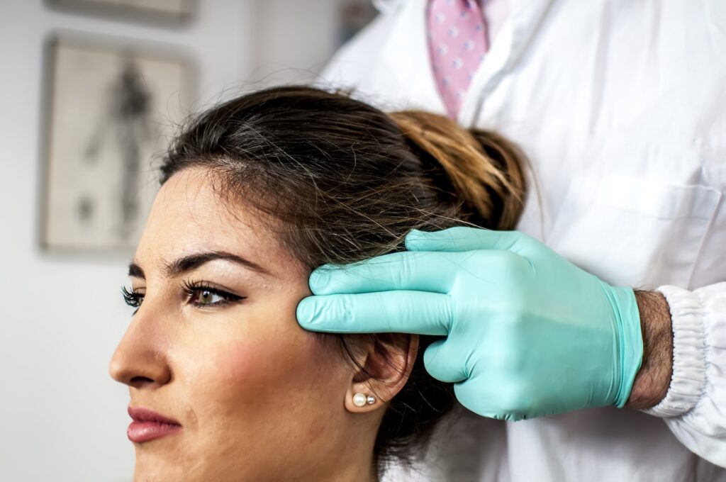 a doctor curing a bad cervical pain and headache of a young girl